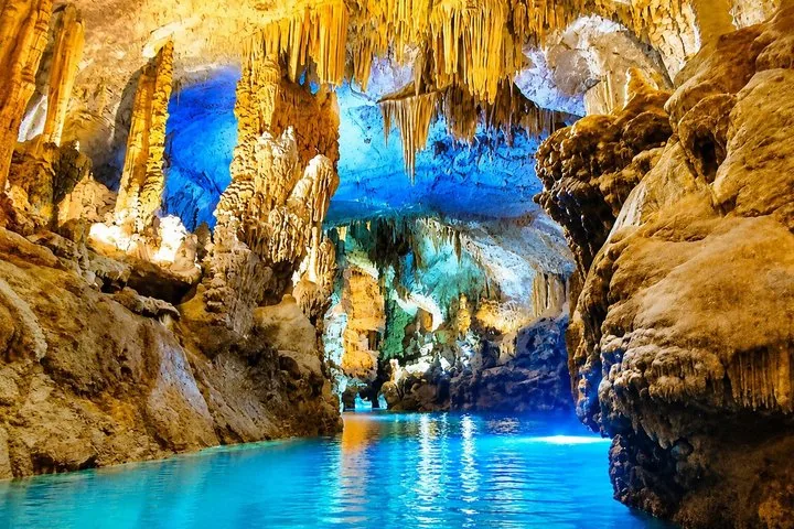 À l’intérieur de la grotte de Jeita, avec de grandes stalactites et une eau bleue illuminée.